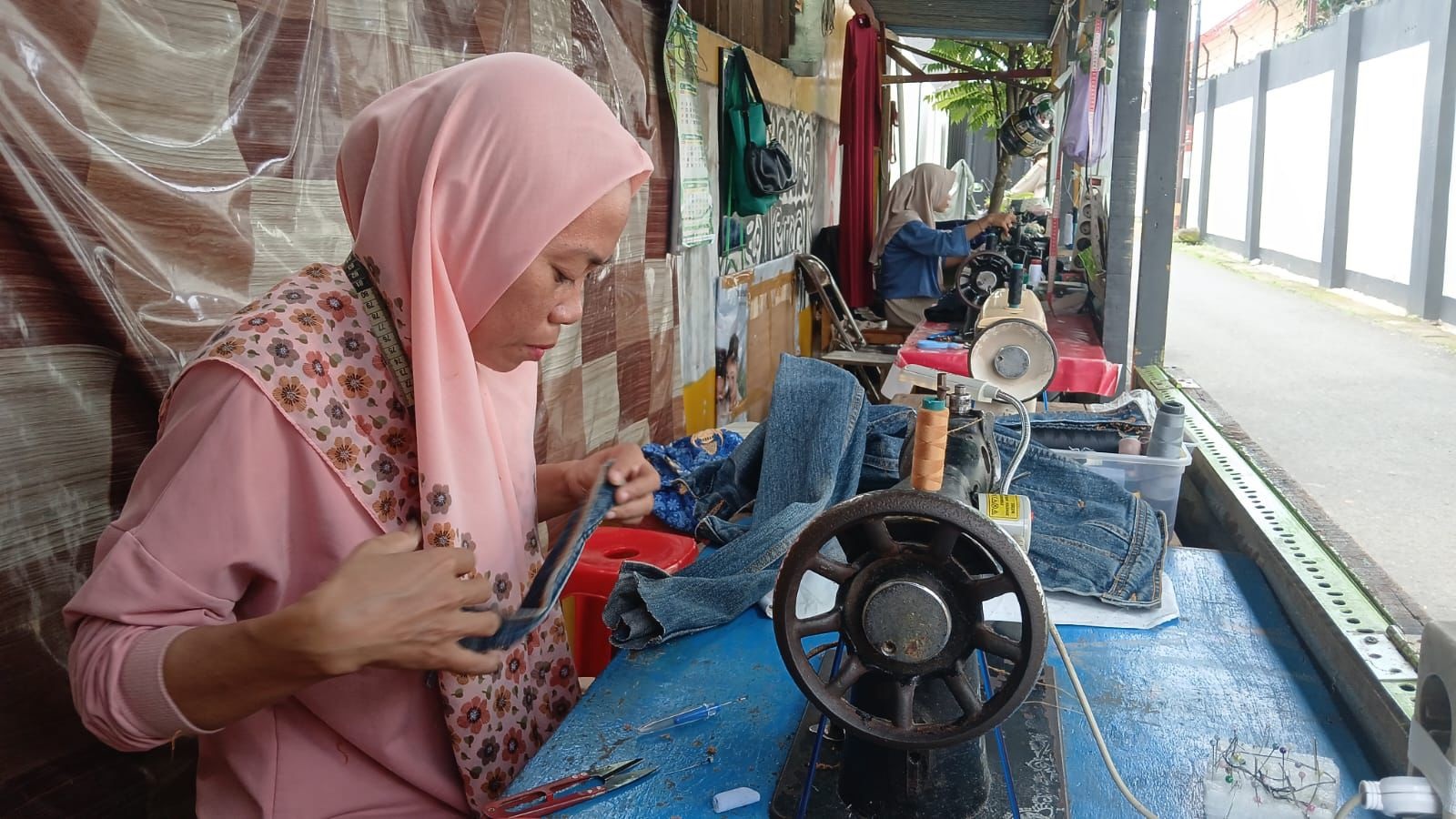 RAMAI PESANAN: Penjahit rumahan tampak sibuk mengerjakan pesanan permak pakaian.