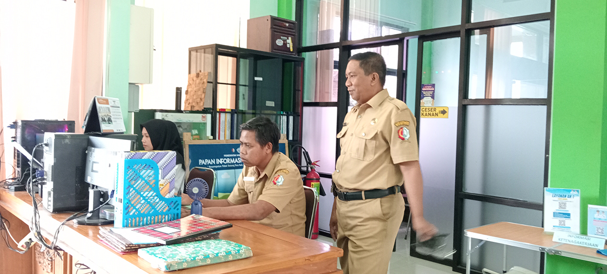 CEK DATA: Kepal Dinperinaker Bojonegoro Mahmudi saat mengecek data di kantornya.