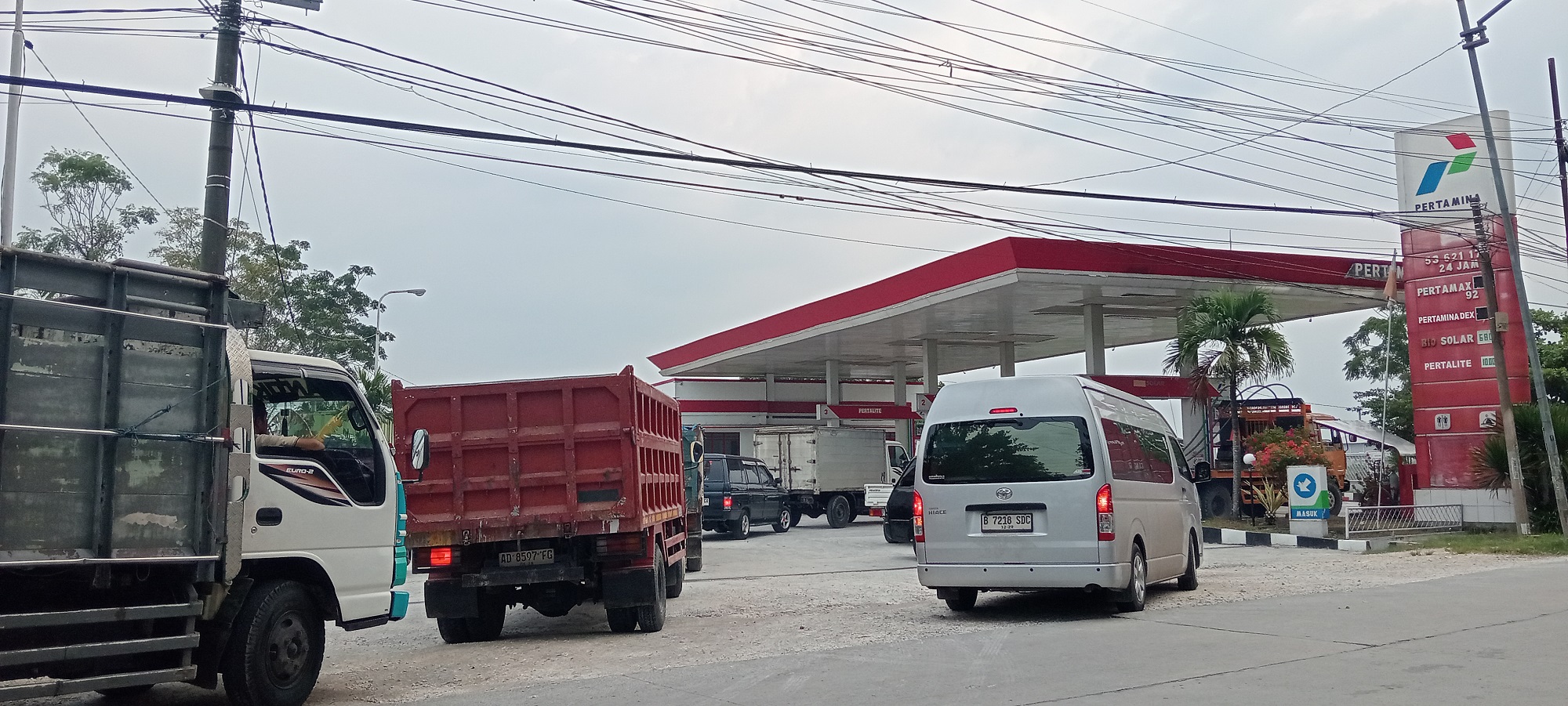ANTREAN: Deretan truk, elf. dan pikap sedang mengantre panjang di SPBU Kalirejo pada Senin sore (9/3).