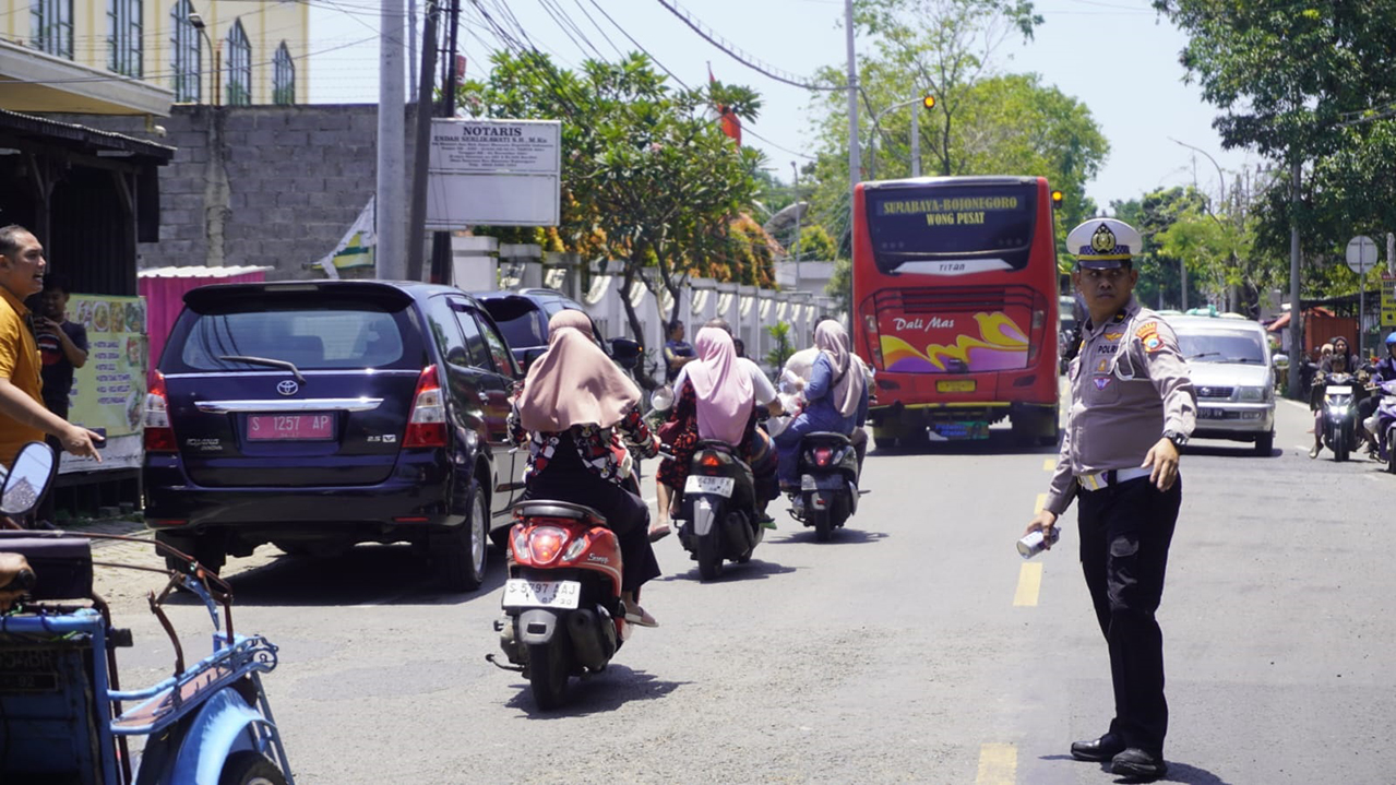 JALAN NASIONAL: Polisi sedang mengatur arus lalu lintas di Jalan Raya Nasional turut Desa/Kecamatan Baureno.
