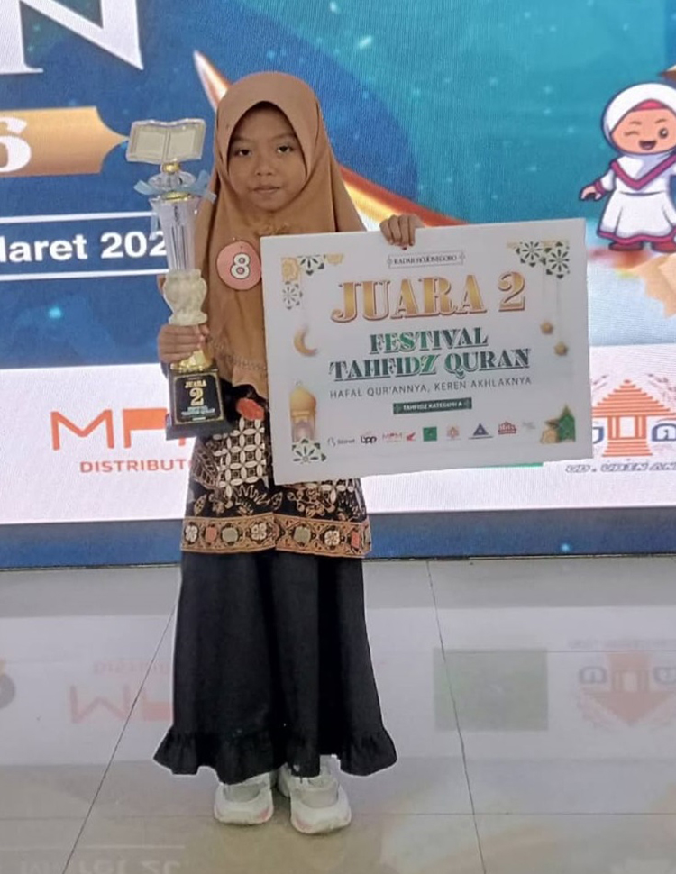 PERCAYA DIRI:  Qanita Hanum Habibah, Juara 2 Kategori A Festival Tahfidz Radar Bojonegoro 2026 menunjukkan piala juara.