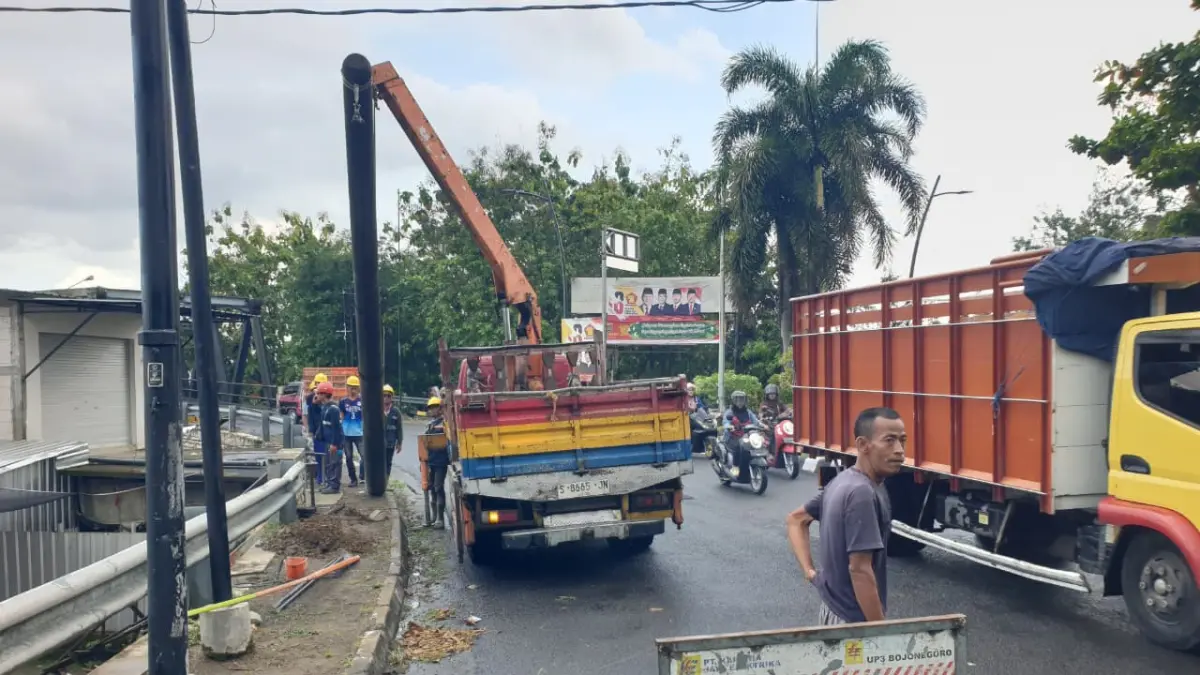 TUMBANG: Tiang listrik hingga reklame di Jembatan Glendeng tumbang setelah diterjang truk gandeng. (HAKAM ALGHIFARI/RADAR BOJONEGORO)