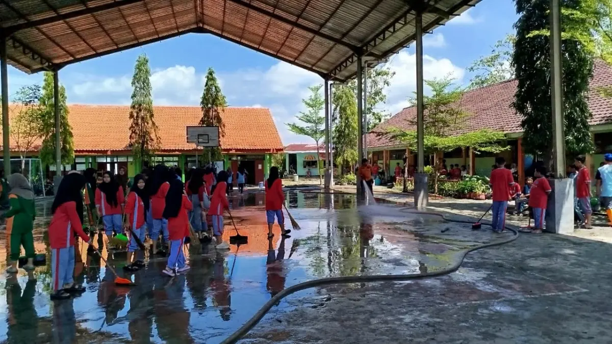 GOTONG-ROYONG: Sejumlah siswa siswi SMPN 4 Cepu membersihkan sisa-sisa banjir di Lapangan. (ACHMAD SYAEROYZI/RDR.BJN)