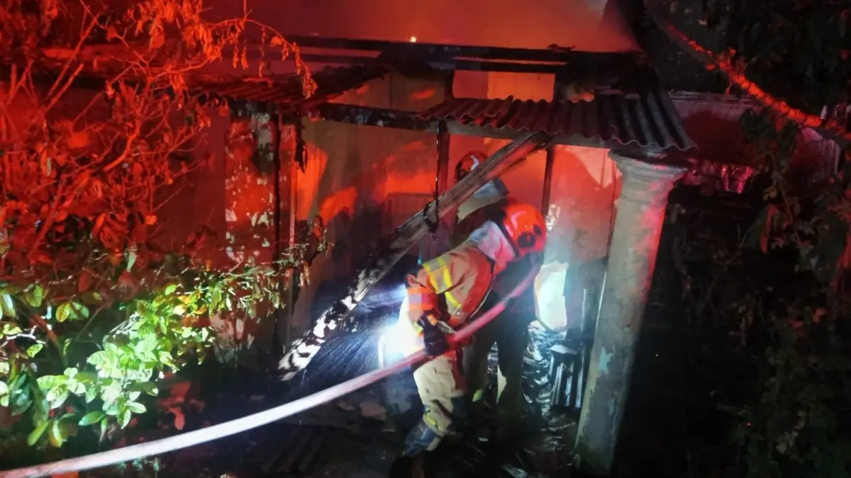 TERBAKAR : Petugas Damkarmat Bojonegoro memadamkan rumah warga Desa Semambung, Kanor yang terbakar. (IST/RADAR BOJONEGORO)