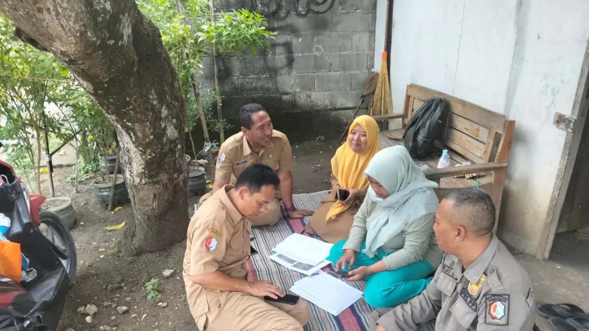 CEK DATA LAPANGAN: Petugas sedang mengecek data anomali DTSEN di lapangan dengan duduk lesehan, ditemukan sejumlah data anomali. (M. IRVAN RAMADHON/RADAR BOJONEGORO)

