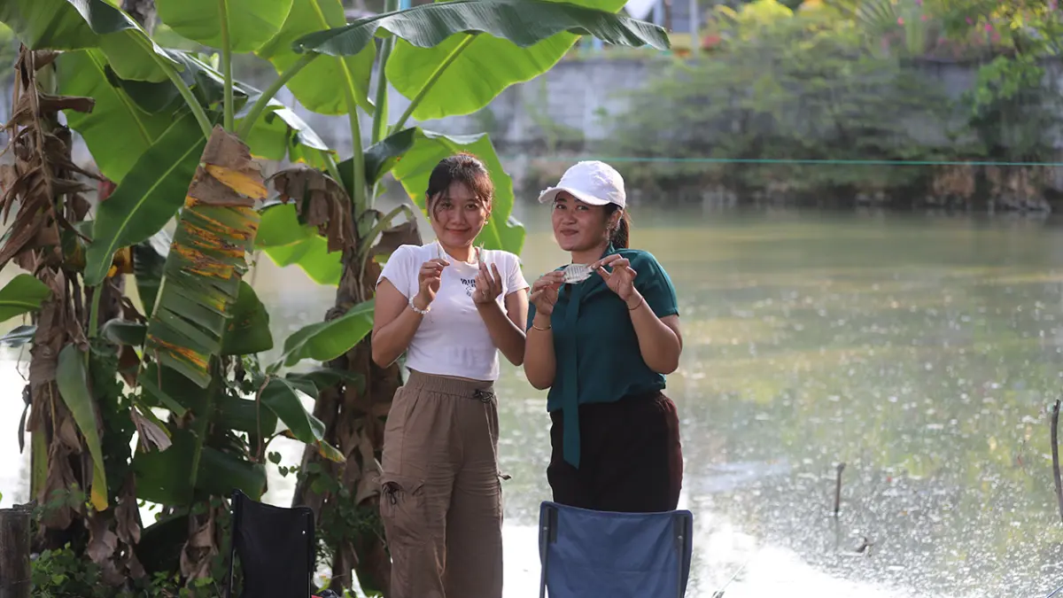 BAHAGIA: Dua cewek dengan bahagia menunjukkan ikan hasil mancingnya. (HAKAM ALGHIVARI/RADAR BOJONEGORO)
