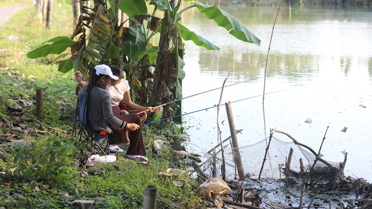 SABAR: Kiki dan Lady dengan sabar memancing ikan di salah satu kolam pemancingan Kecamatan Kapas. (HAKAM ALGHIVARI/RADAR BOJONEGORO)