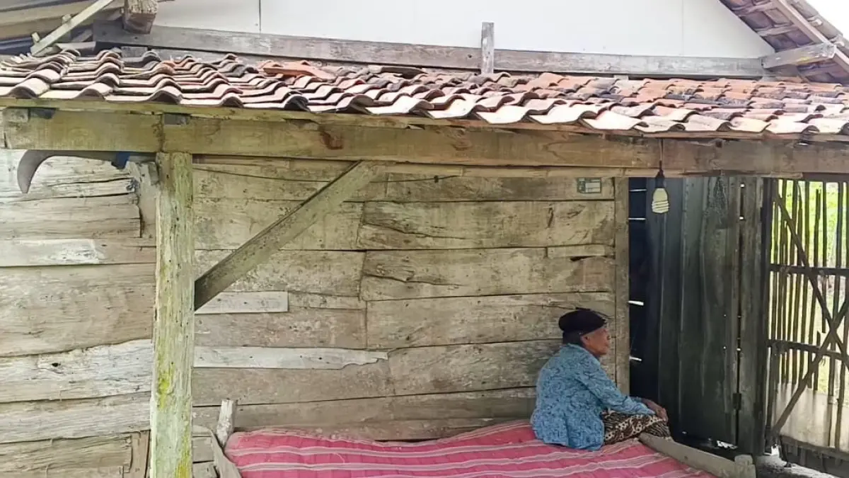 POTRET KEMISKINAN: Nenek Sarni, 90, duduk di dipan reyot depan rumah sederhana miliknya, yang hanya berlantai tanah dan belum memiliki listrik secara mandiri. (ACHMAD SYAEROYZI/RDR.BJN)