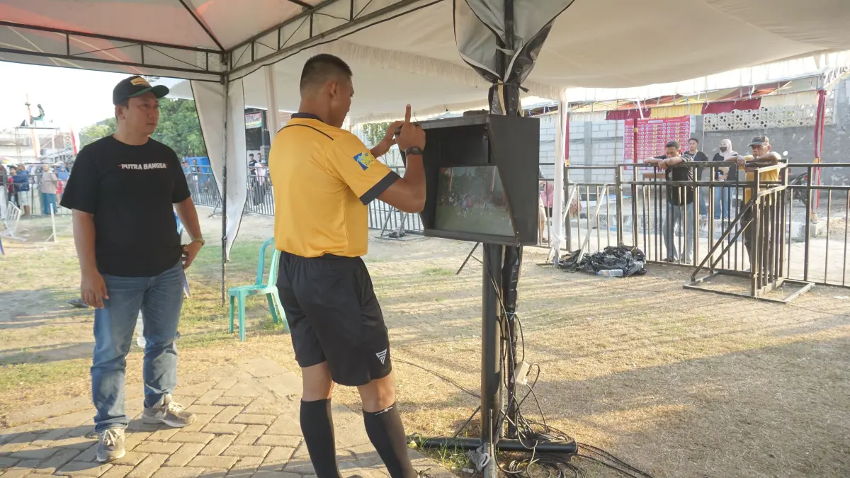 TARKAM: Wasit turnamen sepakbola antar kampung (Tarkam) di Bojonegoro menggunakan video referee assistant (VAR). (ANDHIKA FERIAWAN/RADAR BOJONEGORO)