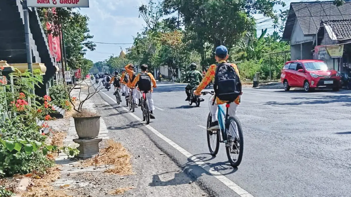 PULANG SEKOLAH: Siswa pulang sekolah dengan naik sepeda, di peringatan HAN tahun ini masih 4.745 anak tidak sekolah. (M. IRVAN RAMADHON/RADAR BOJONEGORO)