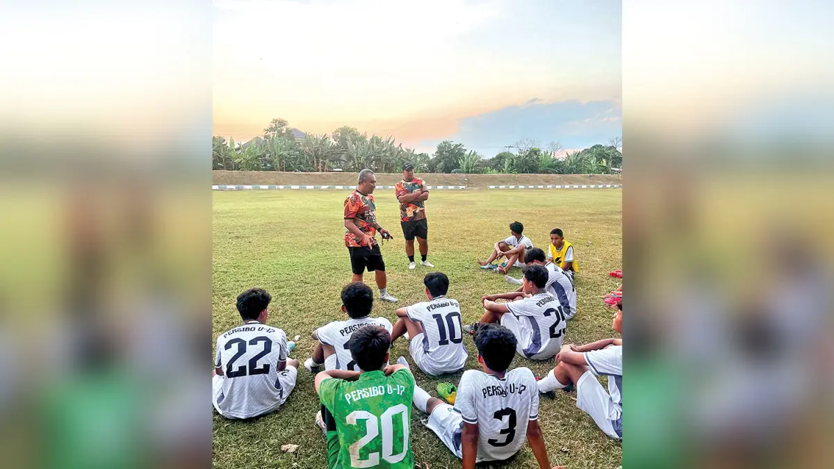 PENGARAHAN:Assisten Pelatih Persibo U-17 Yanuar Andika memberikan instruksi dalam latihan di Lapangan Desa Ngulanan, Kecamatan Dander. Jajaran pelatih Laskar Angling Dharma Muda sedang berkomunikasi dengan beberapa tim untuk melakukan uji coba (M. IRVAN RAMDHON/RADAR BOJONEGORO)