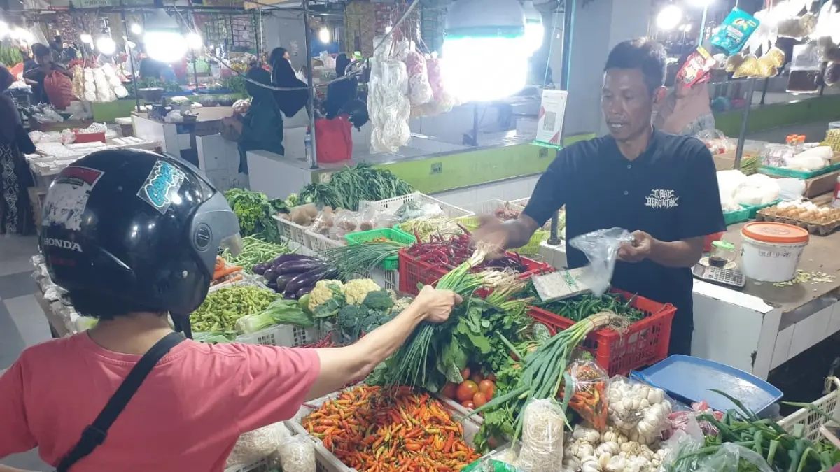 JUAL BELI : Pedagang di Pasar Wisata Bojonegoro sedang melayani pembeli. Saat ini harga cabai naik tajam. (DEWI/RADAR BOJONEGORO)