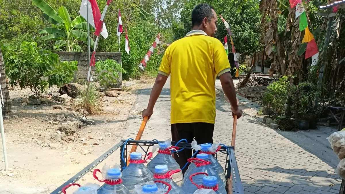 KESULITAN AIR: Warga Desa Tapelan, Kecamatan Kapas ini terpaksa mengusung air untuk mandi, karena mengajukan pemasangan ke PDAM tak kunjung tindaklanjuti. (ISTIMEWA/RADAR BOJONEGORO)