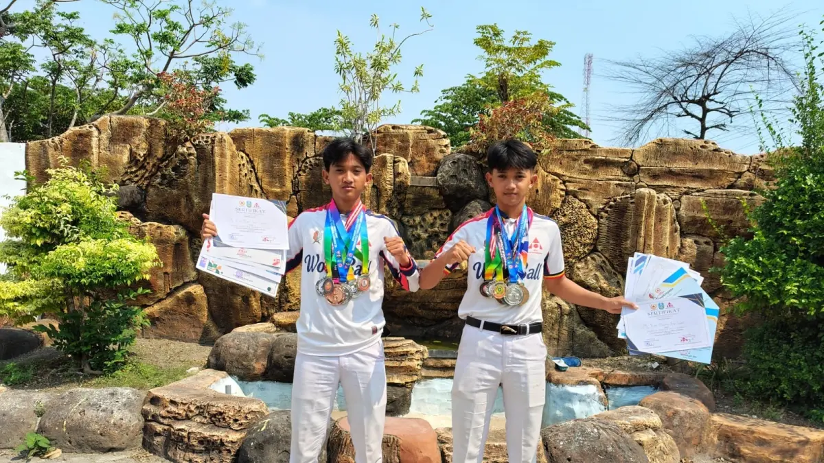 BERPRESTASI: Aldian dan Aldan pamerkan medali dan piagam penghargaan cabor woodball yang berhasil mereka sabet. (ISTIMEWA/RADAR BOJONEGORO)