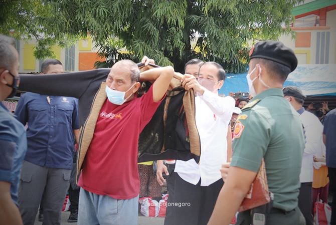 Jokowi Memberikan Jaket Kepada Warga