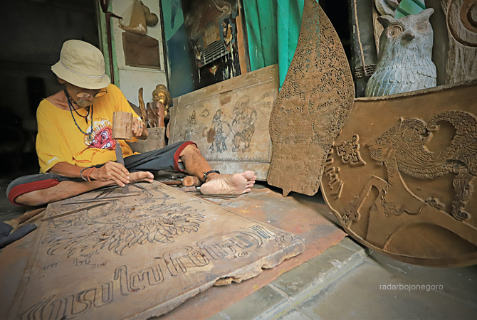 FOKUS: Imam sedang  fokus membuat cukil dekoratif bergambar Kresna Duta di atas papan kayu jati. Rerata tokoh pewayangan, sebagai sarana untuk belajar memahami ragam watak manusia. (M.Nurcholis/R.Bjn)