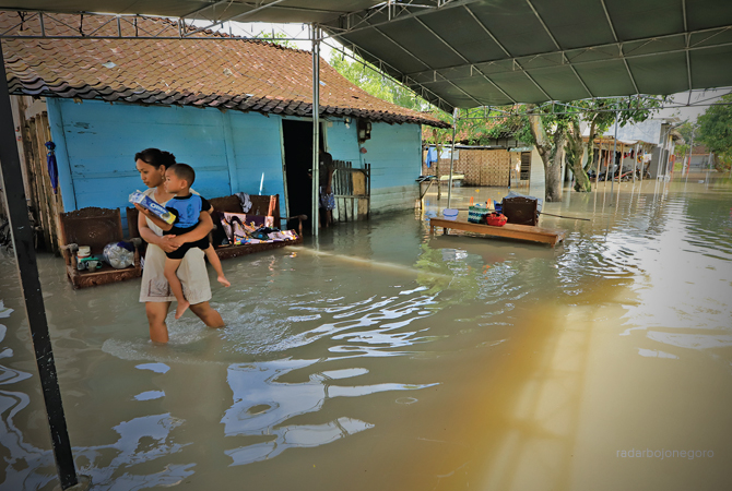 BUTUH SOLUSI: Rumah Lasiman di RT 15 RW 3 Kawasan Pacul Permai kemarin (21/3) masih tergenang banjir usai hajatan resepsi pernikahan. (M.NURCHOLIS/RDR.BJN)