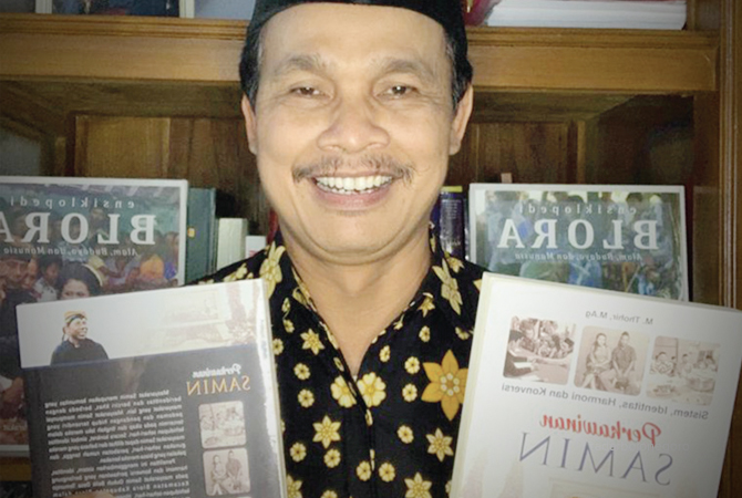 LITERASI BUKU: Thohir menunjukkan buku karyanya. Ia fokus menulis tentang masyarakat Samin. (LUKMAN HAKIM/RDR.BLORA)
