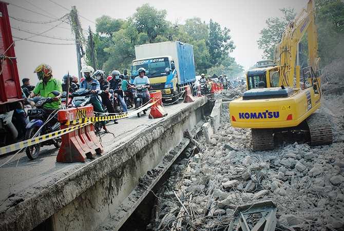 DIBONGKAR: Alat berat masih membongkar konstruksi Jembatan Ngaglik I yang ambles Selasa (29/3). (M. GAMAL AYATULLAH/RDR.LMG)