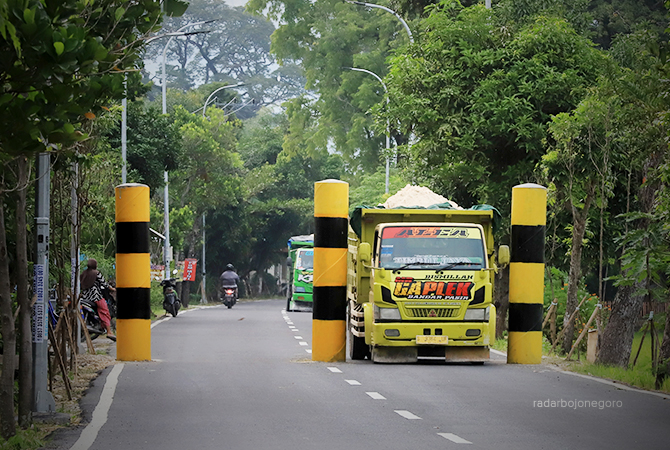 TATA JALAN: Tampak dump truck berusaha melintasi portal dipasang sebelum Jembatan TBT, persisnya di Desa Semambung. Portal upaya membatasi tronton dan bus besar melintas. (M. NURCHOLIS/RDR.BJN)