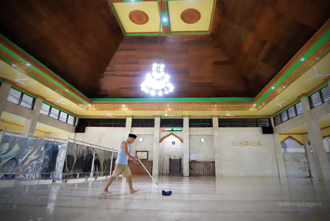 SAMBUT JEMAAH: Seorang marbot membersihkan Masjid Baabusshofa Jalan Gajahmada. (M. NURCHOLIS/RDR.BJN)