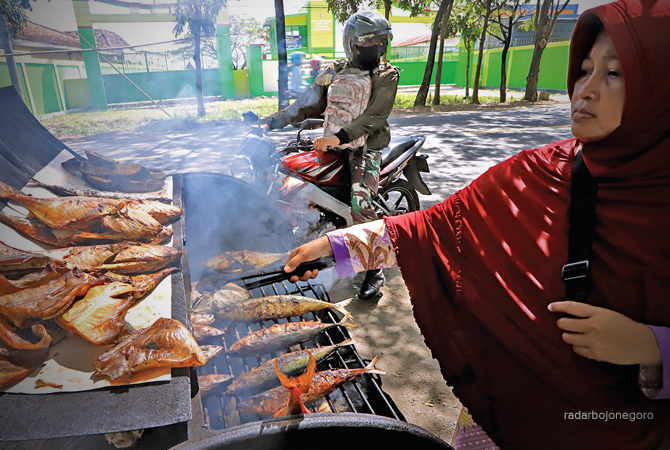 JADI JUJUGAN: Pengendara berhenti dan memilih ikan asap di tepi jalan raya Kecamatan Balen. (M. Nurcholis/RDR.BJN)