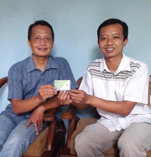 JAMINAN: Manajer pemasaran Jawa Pos Radar Bojonegoro Agus Prasetyo (kanan) menyerahkan kartu BPJS Ketenagakerjaan kepada salah satu agen koran di kawasan Kapas pada Sabtu (25/6). (AGUS PRASETYO/RDR.BJN)