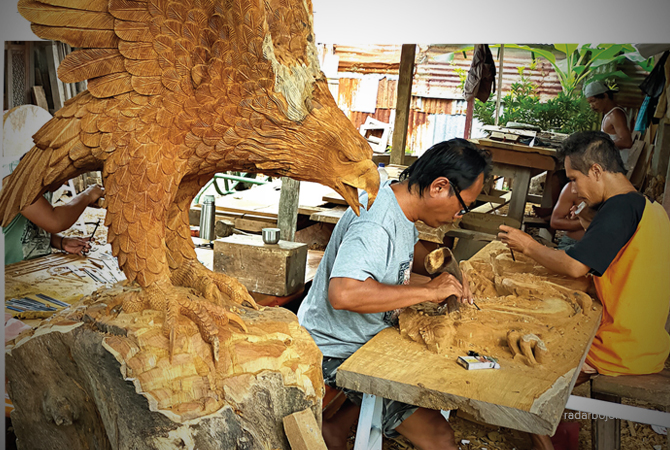 PUNYA MAKNA: Perajin di Desa Campurejo, Bojonegoro, memahat kayu jati berbentuk Pancasila dan Burung Garuda. (M.NURCHOLIS/RDR.BJN)