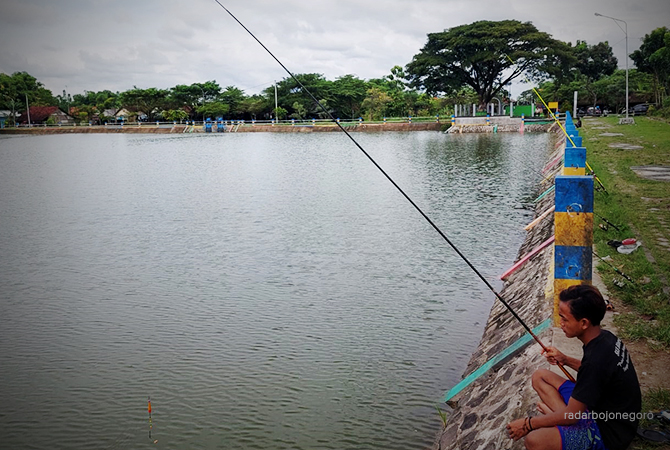 MEMANCING: Warga sedang memancing ikan di Embung Rowo, petugas membebaskan warga menangkap ikan di embung, asalkan tidak dijaring. (Lukman Hakim/RDR.BLORA)