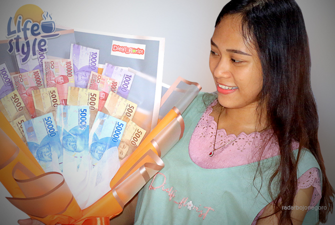 BANYAK DIGEMARI: Dinda menunjukkan salah satu buket yang dihiasi beragam pecahan uang kertas.  (ANJAR DWI PRADIPTA/RDR.LMG)