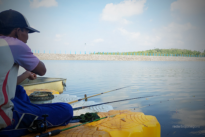 CARI IKAN: Salah satu pemancing santai di Bendungan Tempuran. Bendungan ini jujugan memancing. Lokasinya luas dengan air yang tenang. (Lukman Hakim/RDR.BLORA)