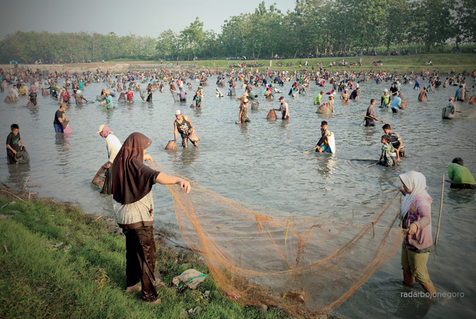GROPYOKAN IKAN: Warga tumpah ruah di Waduk Desa Ngradin, Kecamatan Padangan kemarin (31/7). Menggunakan peralatan sederhana seperti seser atau jaring untuk berburu ragam ikan tawar di waduk. (M. Arif Yanto/RDR.BJN)