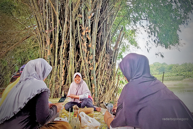 NYAM-NYAM: Pengunjung menikmati ragam kuliner di bawah pohon bambu di tepi Bengawan Solo di Desa Sumberpitu. (Lukman Hakim/RDR.Blora)