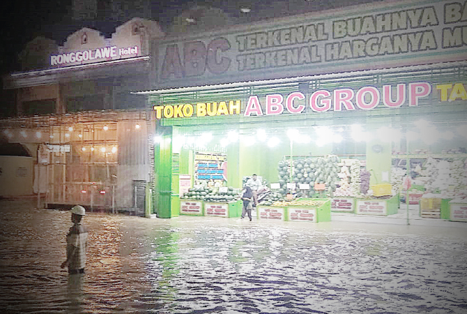 AIR MELUBER: Seorang petugas mengawasi air banjir merendam kawasan Cepu kota. Hingga pukul 20.30 banjir masih terjadi. (Lukman Hakim/RDR.BLORA)