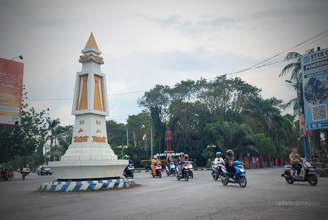 AWAN PETANG: Mendung menggelayut di atas Tugu Cepu. Para pengojek becak motor tampak menunggu penumpang. (Lukman Hakim/RDR.BLORA)