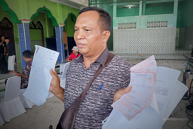 PERTAHANKAN LAHAN: Kades Karangjong melihatkan berkas SPPT setelah pertemuan dengan Menteri ATR/BPN di Ponpes Al Muhammad Cepu, Sabtu (8/10). (LUKMAN HAKIM/RDR.BLORA)