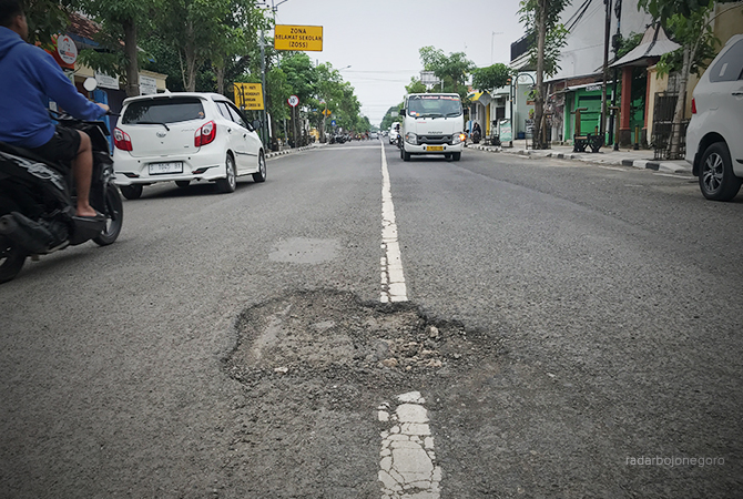 BERLUBANG: Aspal bolong ditemukan di Jalan Mastrip. Juga ada di Jalan Pangsud. Dipicu jalan usai tergenang. (BHAGAS DANI PURWOKO/RDR.BJN)