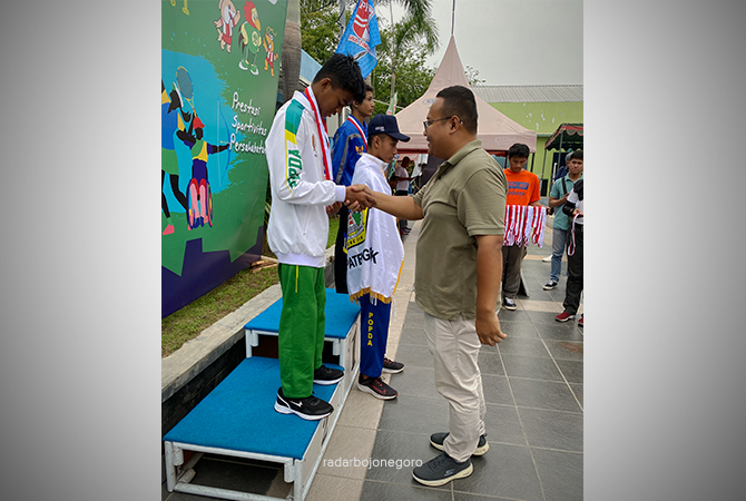 PRESTASI: Hendri Rahman kalungkan medali perak kepada Haviz Rizal Wibowo saat Popda 2022 di Sidoarjo. (Istimewa For RDR.BJN)