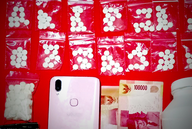 BARANG BUKTI: Uang dan pil dobel L yang diamankan dari tersangka M Rudiyanto, 22, asal Desa Menganti, Kecamatan Glagah. (M. GAMAL A/RDR.LMG)