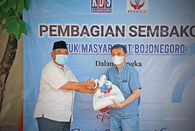 BERI BANTUAN: Owner KDS Bojonegoro, Titus Willy memberikan bingkisan paket sembako kepada Kades Sukorejo secara simbolis. (Achmad Alfatih/RDR.BJN)