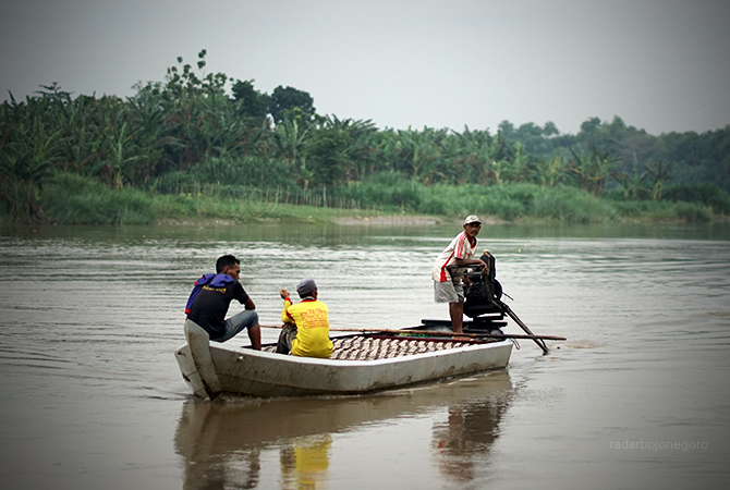SIAGA: Perahu penyeberangan di wilayah Kecamatan Kapas, melintas Bengawan Solo. Perlu waspada menghadapi cuaca ekstrem. (AHMAD ALFIANSYAH MG-1/RDR.BJN)
