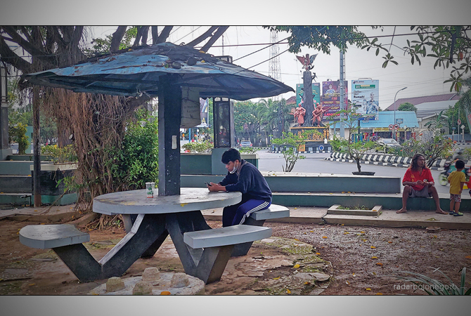 AKSES INTERNET: Warga memainkan gawai di taman kota. Saat ini, upaya pemasangan jaringan fiber optik di beberapa desa. (Lukman Hakim/RDR.BLORA)