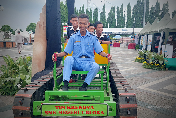 MELALUI RISET: Para pelajar SMKN menaiki mobil pengangkut hasil pertanian menyerupai tank di Alun-Alun Blora. (Lukman Hakim/RDR.BLORA)