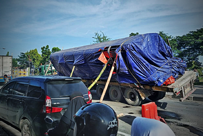 DIBERI PENYANGGA DULU: Truk L 8938 UM yang dikemudikan Dadang Gunarto, 43, asal Desa Kadumadang, Kecamatan Cimanuk, Kabupaten Pandegelang, Banten, posisinya doyong, di jalan nasional masuk Desa Plaosan, Kecamatan Babat kemarin (21/12). (M. GAMAL A/RDR.LMG