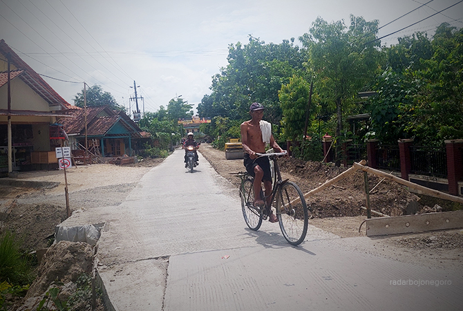 PROYEK FISIK: Warga melintas di jalan Ngawen-Banjarejo, salah satu proyek fisik yang dibiayai dari uang negara. Tahun ini Dinas PUPR Temukan sejumlah proyek molor, diwajibkan membayar denda. (Lukman Hakim/RDR.BLORA)