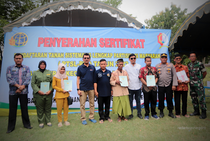 SUKSES: Kades Kuniran, BPN Bojonegoro, dan Forkopimcam Purwosari berfoto bersama perwakilan warga yang menerima sertifikat tanah. Program PTSL di Desa Kuniran terlaksana sukses. Sebanyak 2.688 warga menerima sertifikat tanah. (M. IRVAN RAMADHON/RDR.BJN)