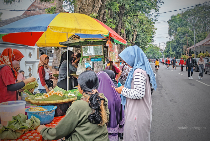 TETA BERJUALAN: Salah satu pedadang CFD tetap berjulan di seputar Apun-alun kemarin (12/2). Rencana pemindahan lokasi CFD itu meresahkan para pedagang. (DHANI WAHYU ALFIANSYAH/RDR.BJN)