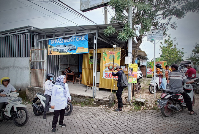 BUTUH KEPASTIAN: Petugas BPN tampak membawa alat mengukur lahan warga di pertigaan Gang Wonorejo, Cepu. (Lukman Hakim/RDR.BLORA)