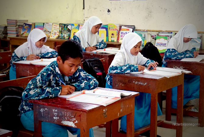 SEKOLAH DASAR: Siswa SDN II Sambiroto saat belajar di kelas kemarin (15/2). Pihak desa tak ingin SDN tersebut dimerger. (YUAN EDO/RDR.BJN)