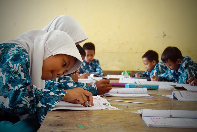 SEKOLAH DASAR: Siswa SDN II Sambiroto saat belajar di kelas kemarin (15/2). Pihak desa tak ingin SDN tersebut dimerger. (YUAN EDO/RDR.BJN)